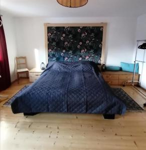 um quarto com uma cama com uma colcha azul em Ferienwohnung "Josefine und Ihr Kavalier" em Kundl