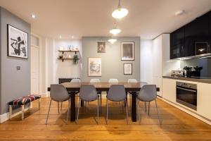 uma cozinha e sala de jantar com mesa e cadeiras em Sherlocks em Londres