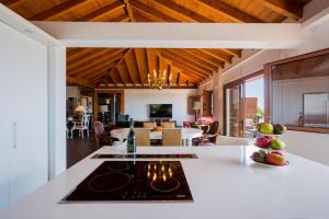 an open kitchen and living room with wood ceilings at Villa Las Rosas, Los Menores, Adeje, sea view in Armeñime