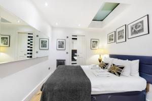 a bedroom with a blue bed and white walls at Sherlocks in London
