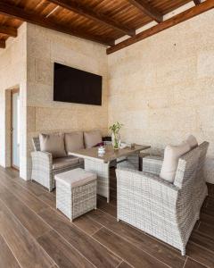 een patio met rieten meubels en een televisie aan de muur bij Casa Valboa in Meis