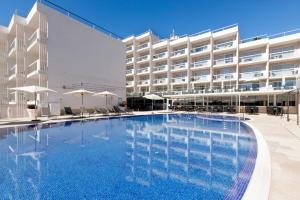 a large swimming pool in front of a hotel at Aparthotel y Hotel Paguera Beach in Paguera