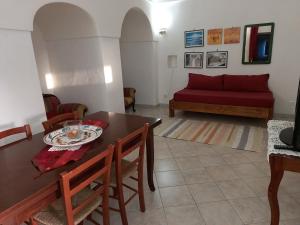 TracinoにあるResidenza dei Baroni - Dammusi Bed&Relax Pantelleriaのリビングルーム(テーブル、赤いソファ付)