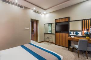 Pokój hotelowy z łóżkiem i biurkiem w obiekcie Myrtle Hotel - Al Sahafa w Rijadzie