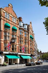 un grand bâtiment avec des drapeaux friables devant lui dans l'établissement Sloane Square Hotel, à Londres