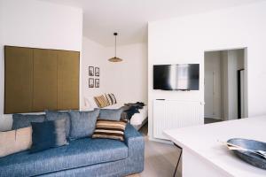 a living room with a blue couch and a kitchen at Smartflats - Louise Brussels in Brussels