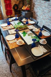 una mesa larga con platos y jarrones azules. en alojamento maritimo II en Espinho