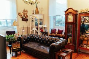 uma sala de estar com um sofá de couro e um relógio em alojamento maritimo II em Espinho