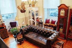 uma sala de estar com um sofá de couro e um relógio em alojamento maritimo II em Espinho