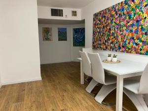 a dining room with a table and chairs and a painting at Las Palmas in Eilat