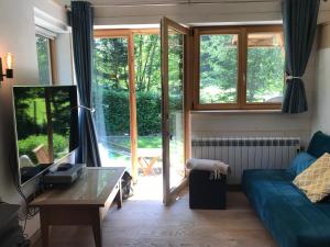 ein Wohnzimmer mit einem blauen Sofa und einem Tisch in der Unterkunft Chalet Cristal Trail in Chamonix-Mont-Blanc