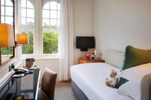 a room with a bed, a chair and a window at Sloane Square Hotel in London