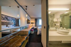 um quarto de hotel com casa de banho com lavatório e banheira em FourSide Hotel Salzburg em Salzburgo