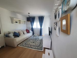 a living room with a white couch and blue curtains at ORKA 5 in Promajna