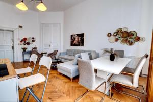 una sala de estar con un sofá, una mesa y sillas en Ultracentral Cozy Apartment on Calea Victoriei with Amazing View, en Bucarest