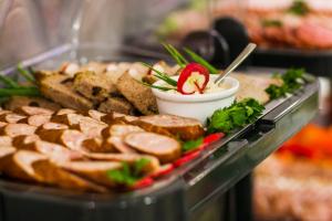 a tray of food with meat and bread and a strawberry at Hotel Olivia in Gdańsk