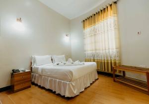 a bedroom with a large white bed and a window at Panama Garden Resort in Moshi