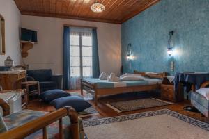 a living room with two beds and a couch at Hotel Faraggi in Tsepelovo