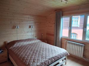 スーズダリにあるGuest House on Turisticheskaya 19の木製の部屋にベッド1台が備わるベッドルーム1室があります。