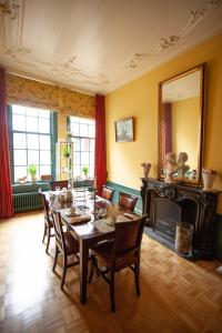 uma sala de jantar com uma mesa e cadeiras e uma lareira em BenB FirstClassEnglish em Dordrecht