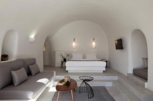 un soggiorno con letto e divano di Elysian Santorini a Oia Altre 37 foto