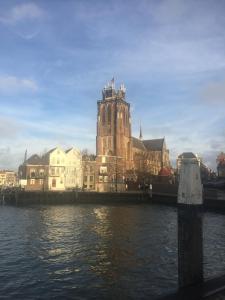 budynek z wieżą zegarową obok zbiornika wodnego w obiekcie BenB FirstClassEnglish w mieście Dordrecht