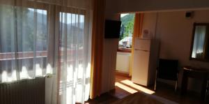 a living room with a large window and a kitchen at Pension Casa Soarelui in Sinaia +19 photos