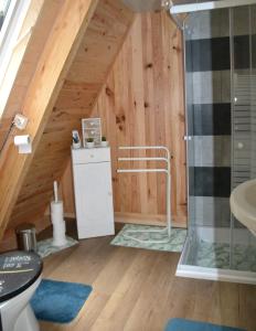 a bathroom with a toilet and a shower in a attic at La Bulle Du Trappeur (Chevaux bienvenus) in Pondrôme
