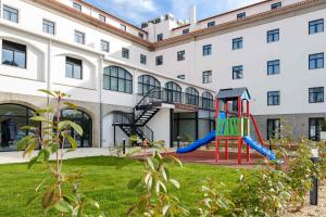 un parque infantil frente a un edificio en SDivine Fatima Hotel, Congress & Spirituality, en Fátima