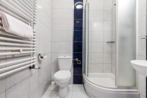 a bathroom with a toilet and a shower and a sink at Hotel Olivia in Gdańsk