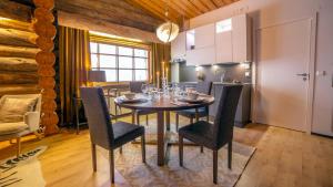 eine Küche und ein Esszimmer mit einem Tisch und Stühlen in der Unterkunft Kuukkeli Log Houses Teerenpesä - Superior Suite A49 in Saariselkä