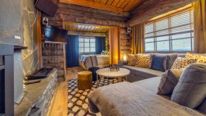 ein Wohnzimmer mit einem Sofa und einem Kamin in der Unterkunft Kuukkeli Log Houses Teerenpesä - Superior Suite A49 in Saariselkä