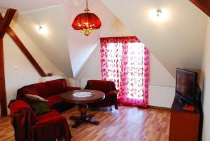 a living room with a red couch and a table at Agroturystyka Gregorczyk in Bogusławiec