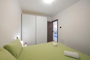 1 dormitorio con 1 cama con colcha verde en Appartamento 3 Il Tornante, en Nesso