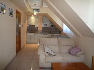 a living room with a white couch and a staircase at Apartamentos Edificio Aguilas in Aínsa