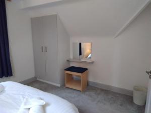 een witte slaapkamer met een bed en een spiegel bij 43 Reidhlean Clifden Glen in Galway