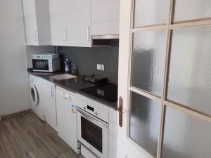 a kitchen with white cabinets and a stove top oven at Apartament Ornis Mascarell Vista Alegre in Sant Carles de la Ràpita