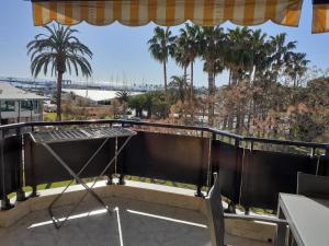 balcón con mesa y palmeras en Apartament Ornis Mascarell Vista Alegre, en Sant Carles de la Ràpita