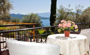 a table with a vase of flowers on a balcony at Valedina Rooms in Nikiana