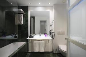 a bathroom with a sink and a tub and a toilet at INNSiDE by Meliá Palma Center in Palma de Mallorca