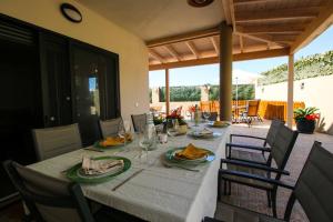 a dining table with plates and glasses on a patio at Villa Golf y Mar in San Miguel de Abona