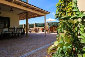 un patio con mesa, sillas y sombrilla en Villa Golf y Mar, en San Miguel de Abona