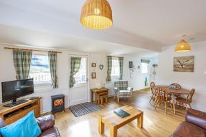 a living room with a couch and a fireplace at Heather Lodge 12 with Hot Tub in Belladrum