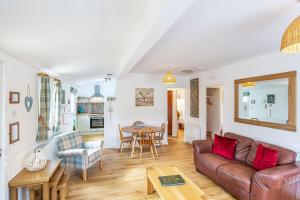 a living room with a couch and a table at Heather Lodge 12 with Hot Tub in Belladrum