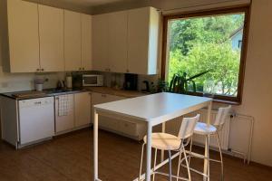 une cuisine avec une table blanche et deux chaises dans l'établissement Villa Edengård, next to Lohja lake, à Lohja