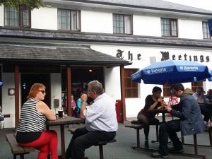 people sitting on a bench in front of a restaurant at The Meetings B&B in Avoca