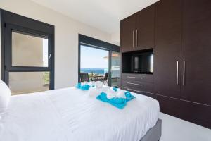 a bedroom with a large white bed with blue flowers on it at Ixia Breeze 3 in Ixia
