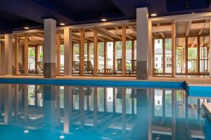 a swimming pool with chairs in a building at Sunstar Hotel Lenzerheide in Lenzerheide