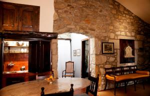 uma sala de jantar com uma mesa e uma parede de pedra em Casa do Ameal em Viana do Castelo