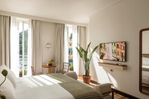 Splendido Mare, A Belmond Hotel, Portofino في بورتوفينو: غرفة نوم بسرير ابيض ونافذة كبيرة